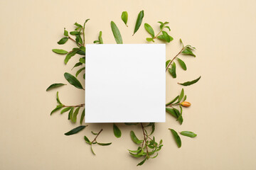 Flat lay composition with pomegranate branches and blank card on beige background. Space for text