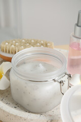 Jar of exfoliating salt scrub on tray