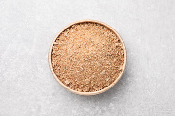Fresh bread crumbs in bowl on grey table, top view