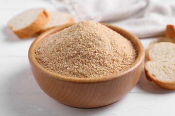 Fresh breadcrumbs in bowl on white wooden table