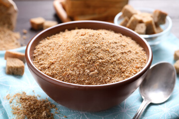 Fresh breadcrumbs in bowl on table, closeup