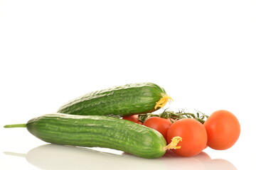 Several green cucumbers and red ripe, cocktail tomatoes on a twig, close-up, isolated on white.
