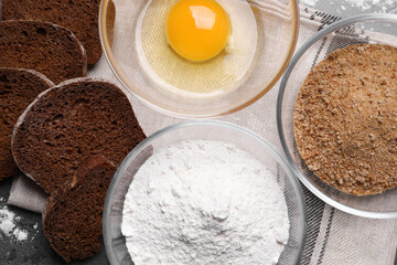 Fresh breadcrumbs, flour and egg on table, flat lay