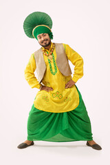 A Bhangra dancer standing with his hands on his waist.	