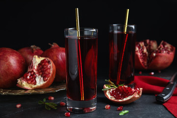 Pomegranate juice and fresh fruits on black table