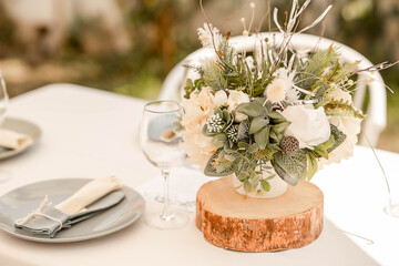 Table arrangement with natural rustic notes featuring herbal floral centerpieces, soft linen table cloth and pastel details, elegant setup for guests at a wedding reception, restaurant or at a party