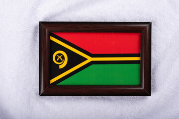 Vanuatu flag in a realistic frame on white cloth background flat lay photo