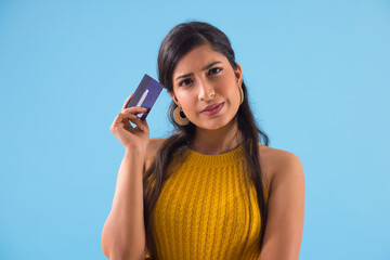 A young woman thinking something with credit card in her hand.	