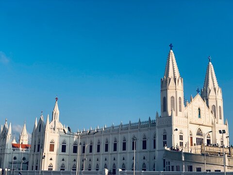 Basilica of Our Lady of Good Health, Sanctuary of St. Mary's shrine, Cathedral of St. Mary, facade of holy trinity. Roman Catholic Latin church tower against blue sky background in Velankanni.