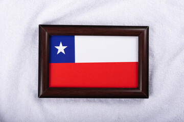 Chile flag in a realistic frame on white cloth background flat lay photo