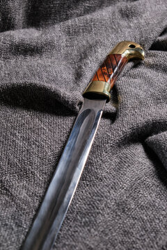 A fragment of a Cossack saber on a rough, dark fabric background. Cold, traditional weapons.