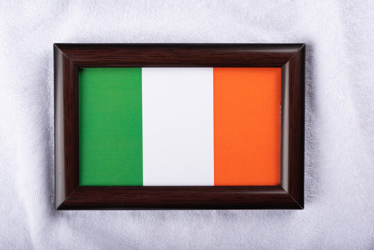 Ireland flag in a realistic frame on white cloth background flat lay photo
