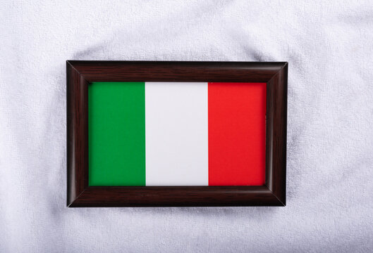 Italy flag in a realistic frame on white cloth background flat lay photo