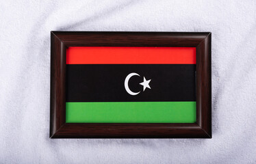Libya flag in a realistic frame on white cloth background flat lay photo