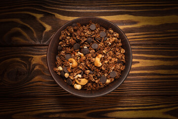 Chocolate granola cereal with nuts in a bowl.