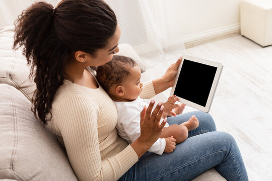 Black Mother With Toddler Baby Video Calling Using Tablet Indoor