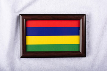 Mauritius flag in a realistic frame on white cloth background flat lay photo