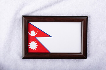 Nepal flag in a realistic frame on white cloth background flat lay photo