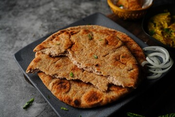 Wholegrain wheat Naan -Indian flat bread served with chicken korma, selective focus