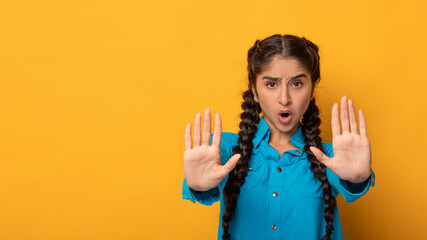 Portrait of a serious indian woman showing stop sign gesture