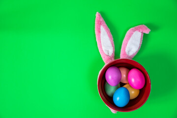 Painted Easter eggs on green plate and pink bunny ears.