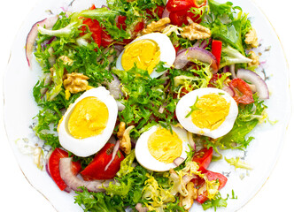salad with lettuce, eggs,onions,nuts and tomatoes