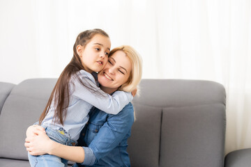 Mom with her pre teen daughter hugging, positive feelings, good relations.