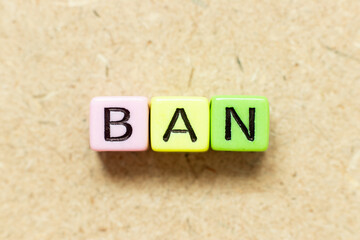 Color alphabet letter block in word ban on wood background