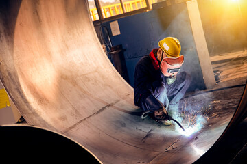 Asian workers are welding steel and sparks are flying