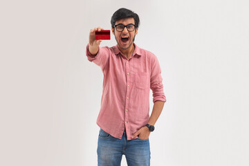 A young man excitedly showing his credit card.	