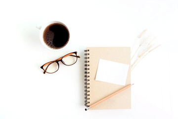 Notebook with of dry grass, glasses and coffee on white background. flat lay, top view, copy space.