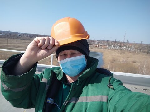 An industrial worker in a helmet and a mask.