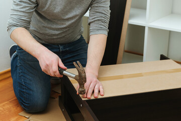 Man assembling new furniture at home. Furniture assembly yourself.