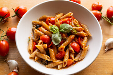 Penne pasta with tomatoes and black olives