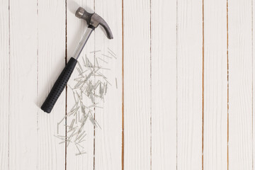 hammer and nails on white wooden background