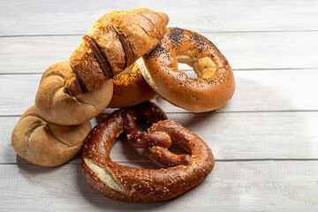 Sweet yeast baked goods. Bagels, donuts croissants pretzels. On a light background.