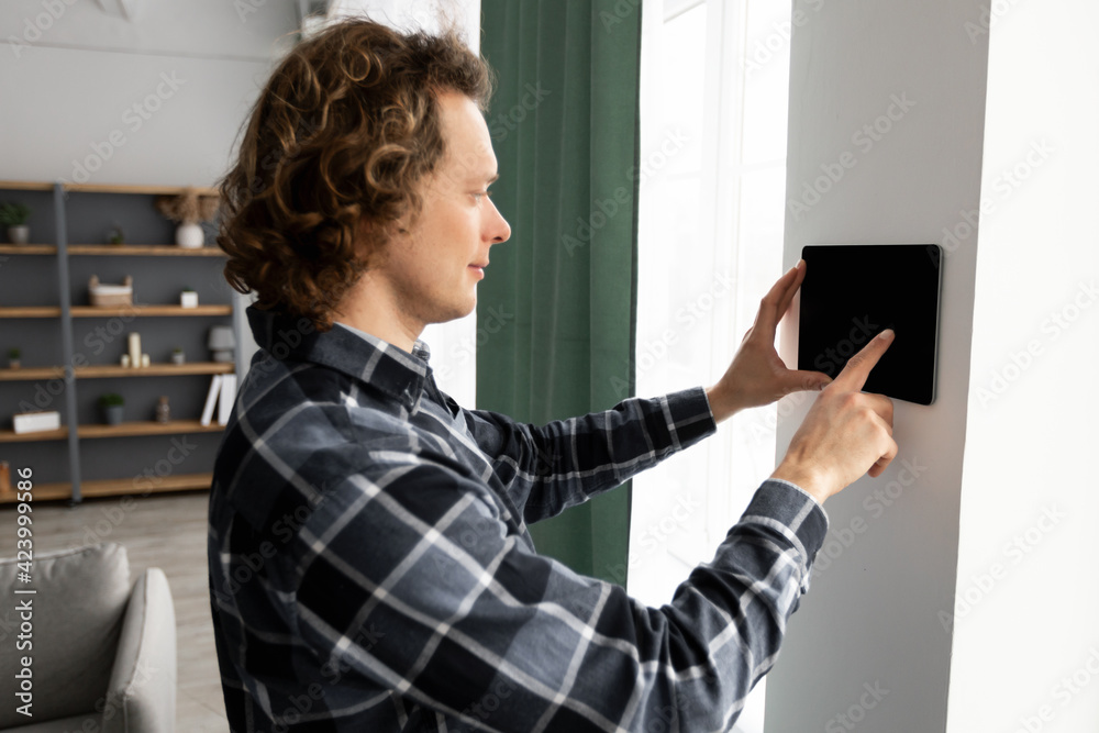 Aufkleber Man Using Smart Home Control System On Digital Tablet Indoors