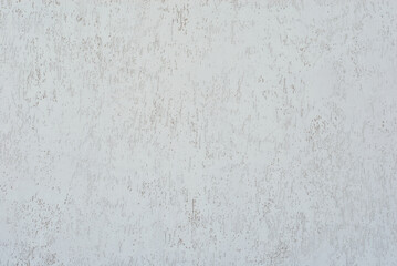 White concrete wall with cracks and scratches. Texture of scratched, old and worn wall close up.