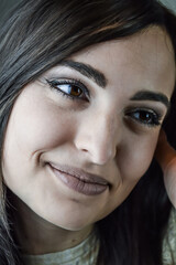 Fototapeta premium Portrait of a beautiful young woman with long dark hair who smiles tenderly