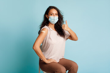 Vaccinated Woman Gesturing Thumbs-Up After Coronavirus Vaccination On Blue Background