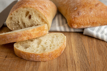 fresh bread slice on wooden rustic table, italian ciabatta bread close up