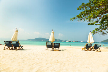 Sunshades, umbrellas and deckchairs are placed at public beach for a perfect holiday.