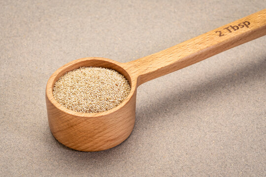 gluten free ivory teff grain in a wooden measuring scoop, important food grain in Ethiopia and Eritrea