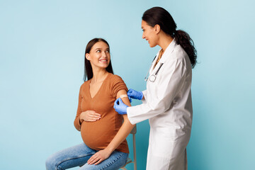 Pregnant Female Patient Getting Vaccinated Against Coronavirus Over Blue Background