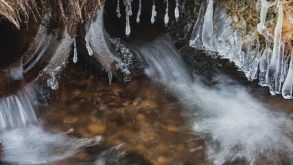 Sople lodowe i woda wyplywajaca z rury © Jaroslaw