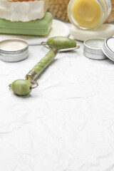  Natural organic skin care product. Home spa and self care concept. Facial serum, jade roller and soap bar with copy space.