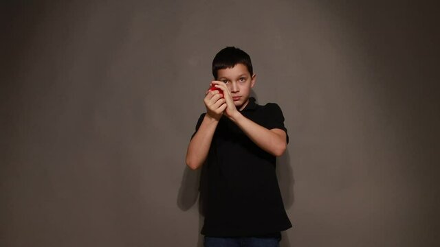 Boy teenager shows trick with red hearts. Hobbies for children and adolescents, video
