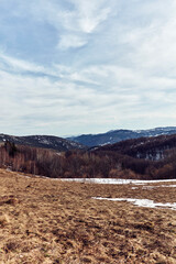 View from a mountain top with some snow on distant hills.