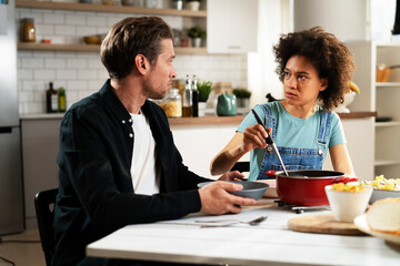 Loving couple eating lunch together at home. Husband and wife enjoying in tasty meal.