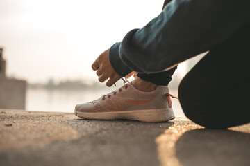 Woman tying shoe laces. Woman fitness runner get ready for jogging on way in the city.